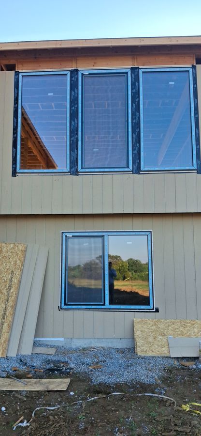 Window installation in progress on a two-story home
